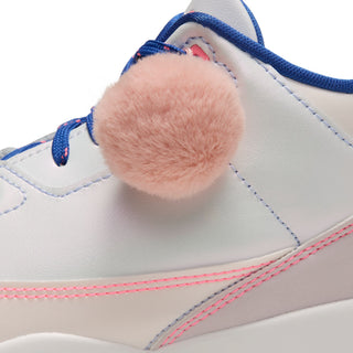 Close-up of a soft pink pom-pom attached to the sneaker's blue laces