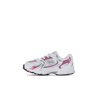 Toddler sneakers side view in white with pink details and textured rubber sole