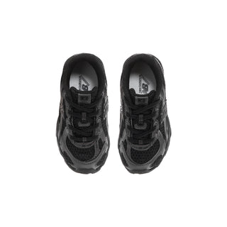 Toddler black sneakers showing inner tongue and laces, lace-up low-top fit