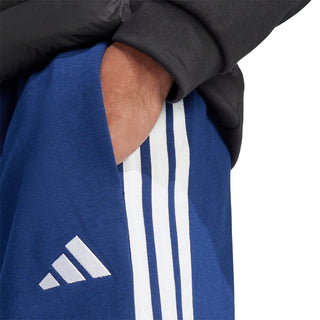 Dark blue fleece pants close-up with Adidas logo and white side stripes