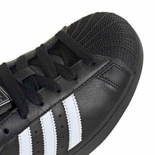 Close-up of women’s adidas Superstar II black leather upper with white triple stripes