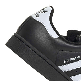 Close-up of women’s adidas Superstar II heel with white adidas label and black leather