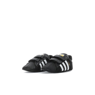 Infant black adidas Superstar sneakers shown from side with double Velcro straps