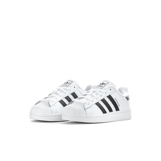 Kids' white adidas sneakers with three black stripes and lace-up front.