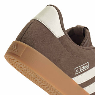 Women’s sneaker quarter panel close-up with adidas logo, taupe suede, white stripe accents