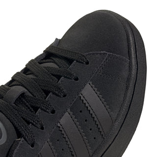 Youth black suede sneaker upper close-up with three stripes and laces