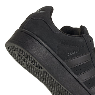 Youth black suede sneakers close-up of side logo and patterned rubber outsole