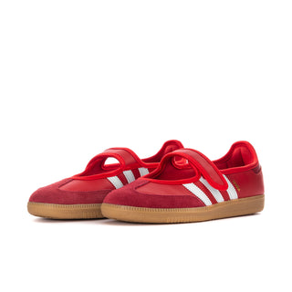 Pair of red adidas low-top sneakers with white stripes and gum rubber sole.