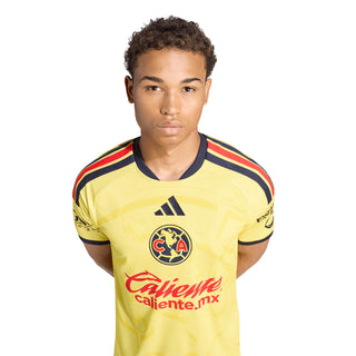 Yellow mens soccer home jersey front view with crest, Adidas logo, and Caliente sponsor