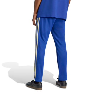 Men's blue track pants with gold side stripes and tapered leg opening