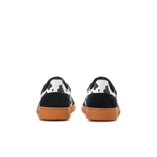 Youth black sneakers with cowprint heel panel, white stripes, gum outsole