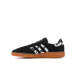 Youth black suede sneaker with white serrated stripes and gum-orange sole