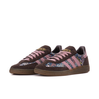 Pair of women's low-top sneakers with dark brown suede, mauve laces, blue patterned side panels.