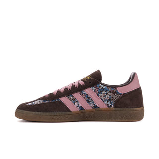 Women's low-top sneaker side view with dark brown suede, mauve stripes, blue patterned quarter.