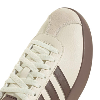 Women’s off-white sneaker side close-up with brown panels and lace-up detail