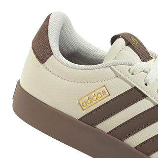 Women’s off-white sneaker side close-up with adidas label, brown stripes, and textured sole