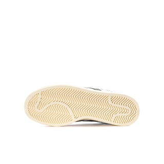 Youth white sneaker outsole view with textured tread on rubber sole