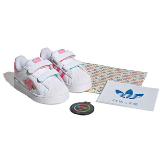 Toddler sneaker set with white pair, pink accents, and included Care Bears insert card
