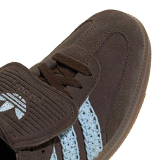Close-up of dark brown suede upper with light blue laces and three-stripe detail