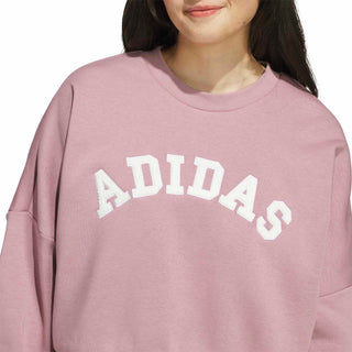 Women’s mauve sweatshirt close-up of raised ADIDAS logo lettering