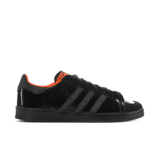 Men's black low-top sneakers with three stripe panels and orange lining accents