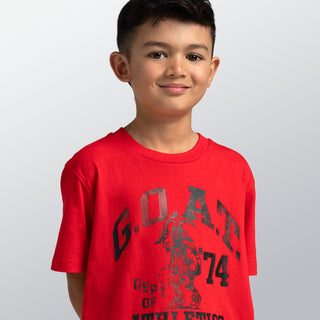 Child wearing a red t-shirt with black text and graphics on a light gray background
