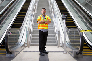 Male worker posing in front of escalator