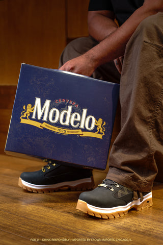 Men's black lace-up boots with gold plaid accents and white chunky soles, boxed