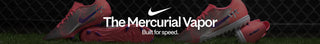 Red soccer cleats with Nike branding on a grass field background