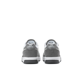 Kids New Balance sneakers, heel view in gray with white sole and branding
