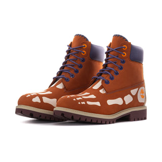 Pair of men's brown and indigo lace-up boots with white splash print, rugged tread.