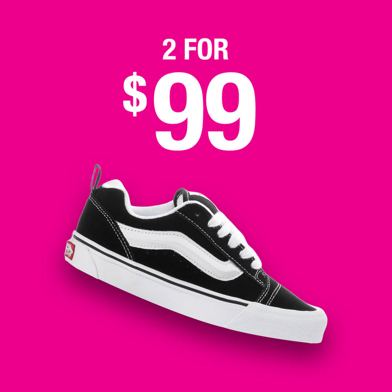 A black and white Vans sneaker shown against a bright pink background with a price reading '2 FOR $99'.