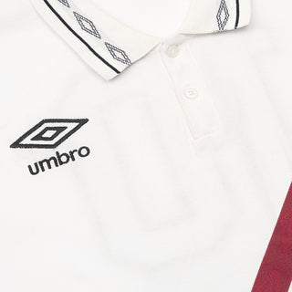 White polo shirt placket with button and Umbro logo on chest