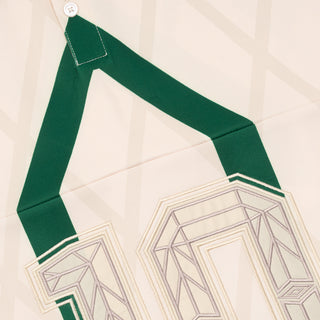Off-white jersey with green yoke trim and geometric panel graphic