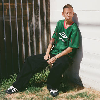 Men's green soccer jersey with Umbro logo and red trim
