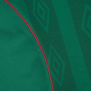 Green jersey fabric close-up with red piping along the seam