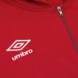 Red hoody close-up: Umbro logo on chest and metal zipper at center