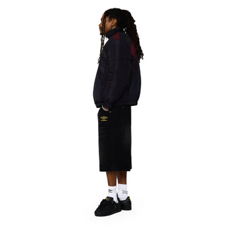 Men's black denim carpenter shorts, side profile with small Umbro logo on leg