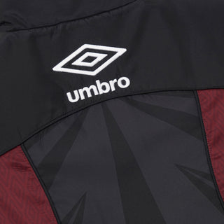 Close-up of Umbro logo on black windbreaker with maroon side panel