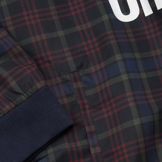 Plaid windbreaker fabric detail with ribbed cuff, dark navy and red/black check.