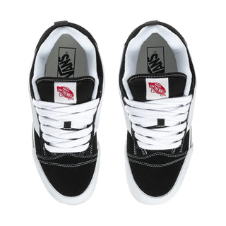 Men's black-and-white sneakers with white laces, tongue label patch, and padded collar