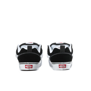 Men's black-and-white sneakers, back/heel view with branding patch and white rubber sole