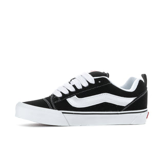 Men's black-and-white low-top sneakers, angled side view with white laces and stripe detail