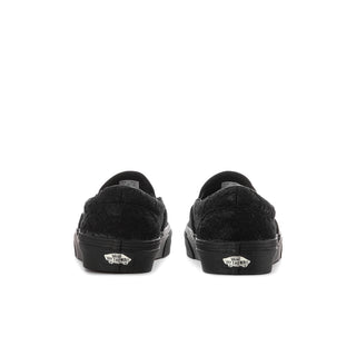 Women's black slip-on sneaker with heel tabs and flat rubber sole