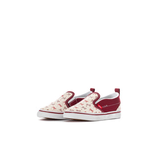 Toddler slip-on sneakers, side view: white canvas with red bow print and bordeaux trim