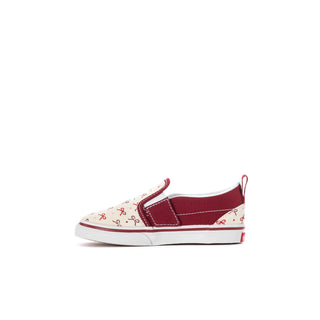 Toddler slip-on sneakers, angled front view: bordeaux trim with white bow-pattern canvas