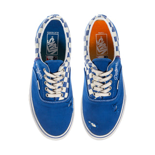 Men's low-top Vans sneakers with blue canvas, white checker laces, and padded collar