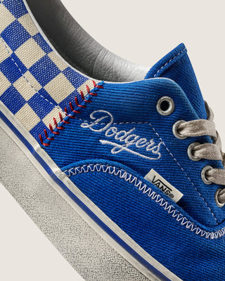 Men's low-top Vans sneakers detail: blue suede, checkerboard trim, and metal eyelets