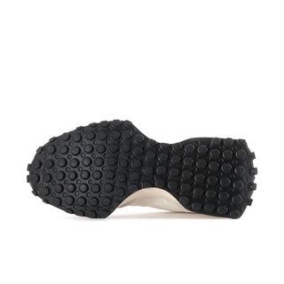 Women's sneaker outsole with dark traction pods and beige midsole edge