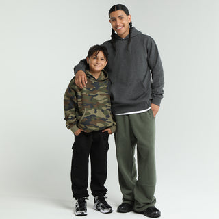 Youth black fleece cargo pants worn by a child, elastic cuffs and cargo pocket detail